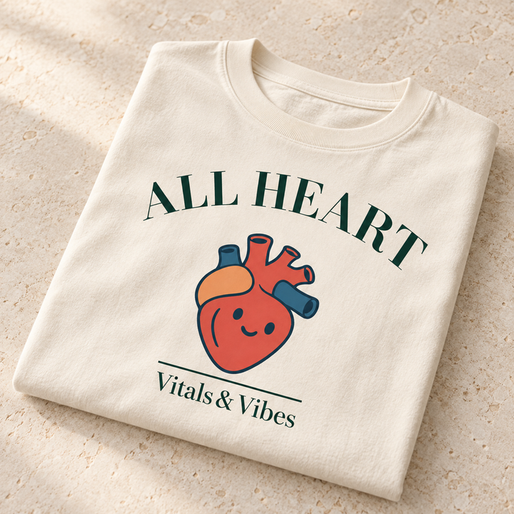All Heart tee in Ivory, folded for a close detail view, showing the All Heart lettering and smiling anatomical heart design.