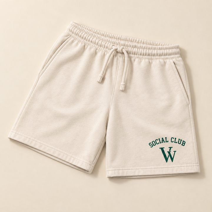 Garment-dyed sweatshorts in Ivory, laid out on a table, showing the design and garment details.