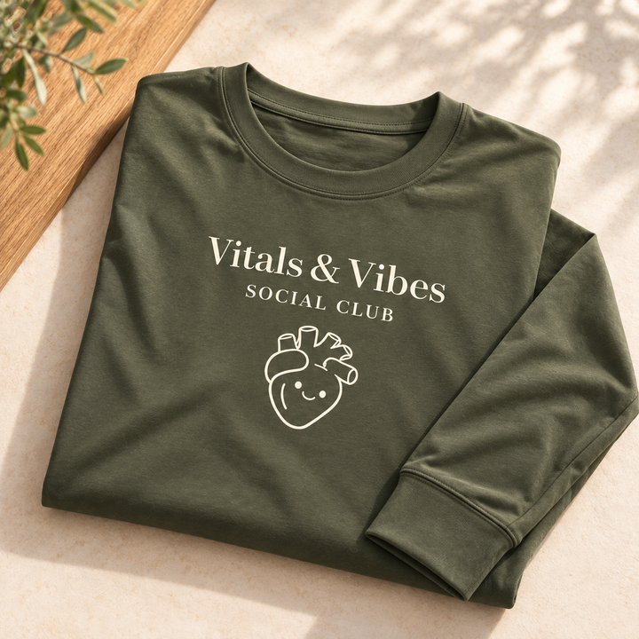 Planned design preview: folded garment detail of olive performance long sleeve with cream Vitals & Vibes, Social Club and smiling heart print