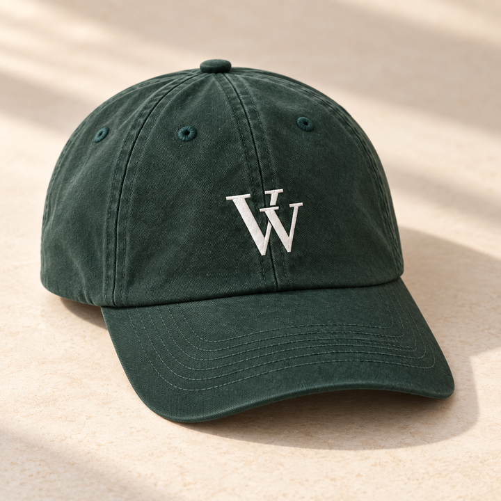 Spruce Everyday Dad Cap resting on ivory stone, showing the white VV embroidery, six-panel crown and curved brim from a front three-quarter angle.