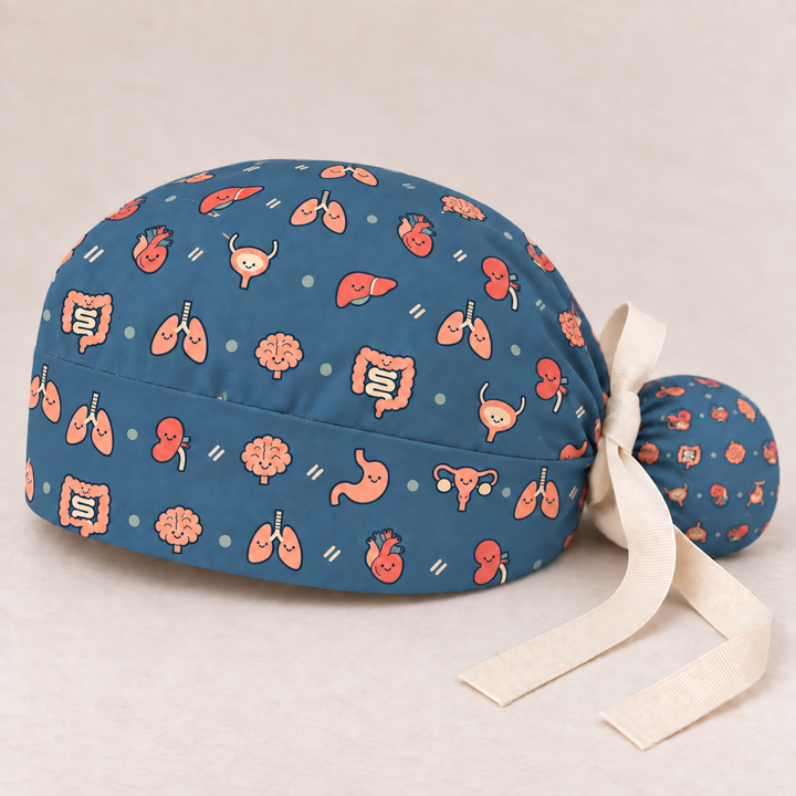 All Organs ponytail scrub cap — studio mockup showing the printed cap and cream ties.