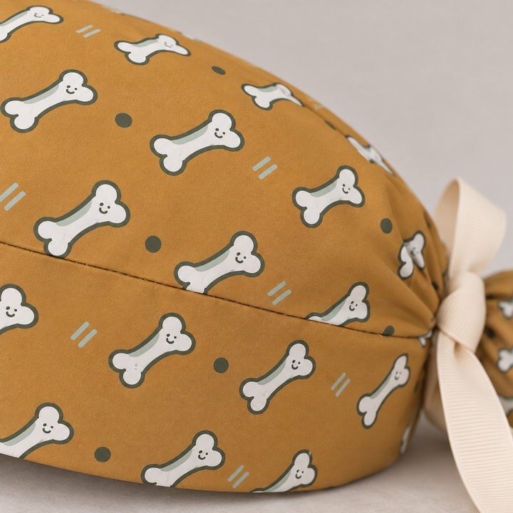 Bone ponytail scrub cap — close-up mockup showing the printed fabric and stitched seam.