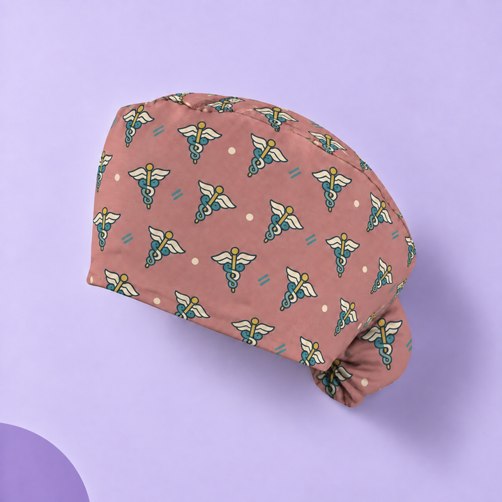 Caduceus Ponytail Scrub Cap — Studio view of the printed cap on a coordinated background.