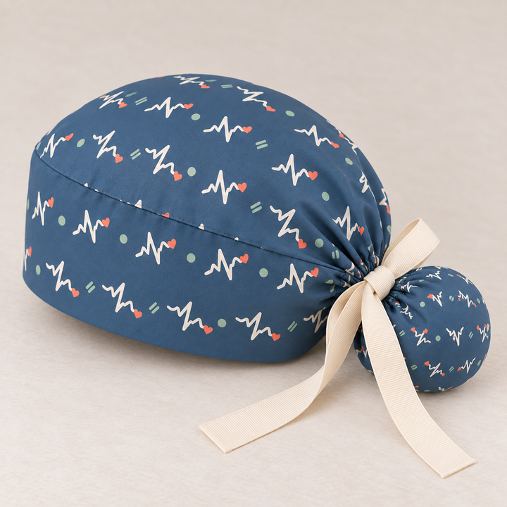 ECG ponytail scrub cap — studio mockup showing the printed cap and cream ties.