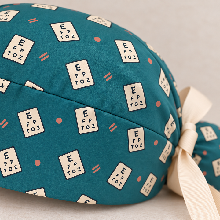 Eye Chart ponytail scrub cap — close-up mockup showing the printed fabric and stitched seam.