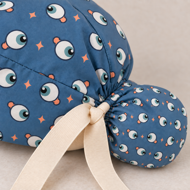 Eye ponytail scrub cap — close-up mockup showing the printed fabric and stitched seam.