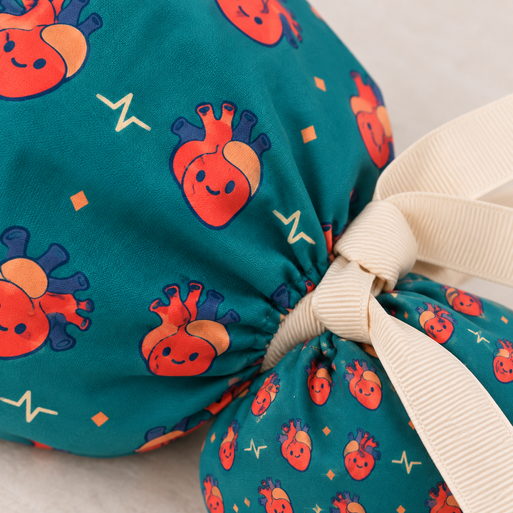 Heart ponytail scrub cap — close-up mockup showing the printed fabric and stitched seam.