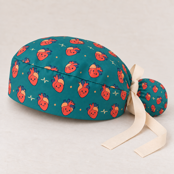 Heart ponytail scrub cap — studio mockup showing the printed cap and cream ties.