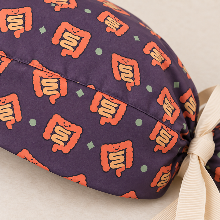 Intestine ponytail scrub cap — close-up mockup showing the printed fabric and stitched seam.