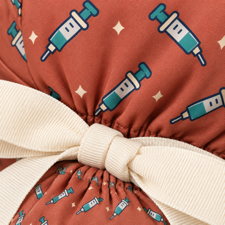 Needle ponytail scrub cap — close-up mockup showing the printed fabric and stitched seam.