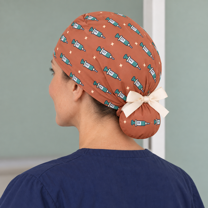 Needle Ponytail Scrub Cap — Rear worn view showing the printed ponytail pouch and cream ribbon bow.