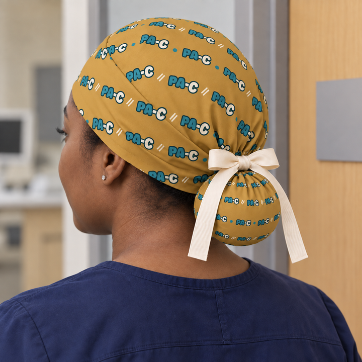 PA-C ponytail scrub cap worn with plain scrubs in a clinical-setting mockup.