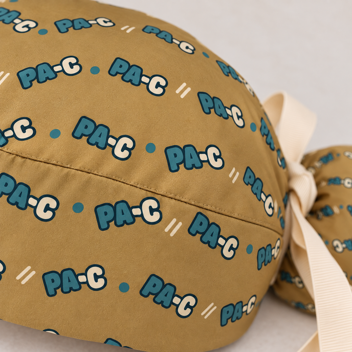 PA-C ponytail scrub cap — close-up mockup showing the printed fabric and stitched seam.