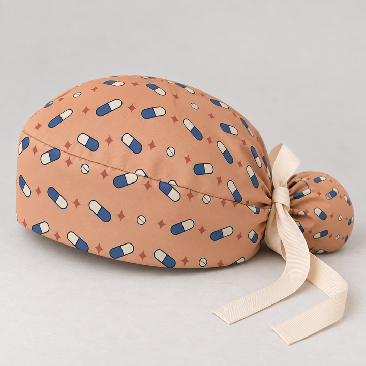 Pill ponytail scrub cap — studio mockup showing the printed cap and cream ties.