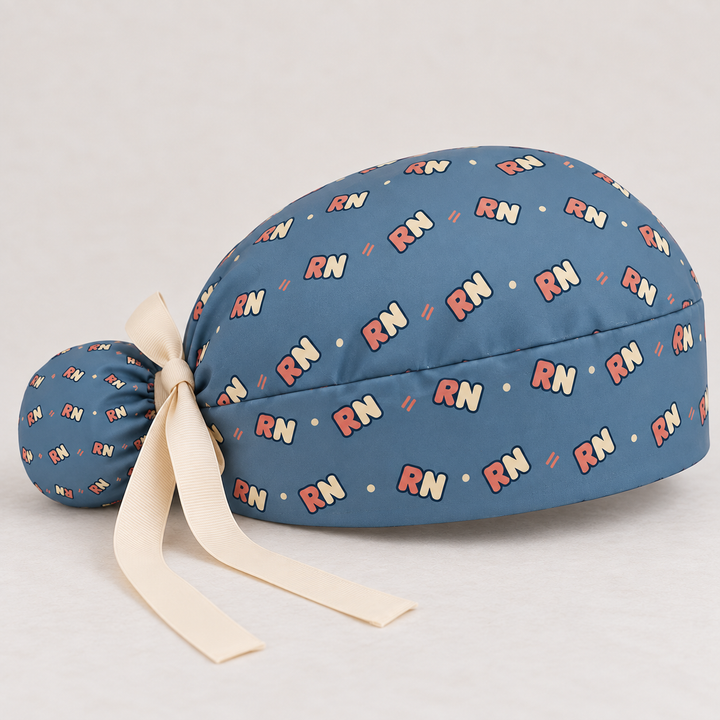 RN ponytail scrub cap — studio mockup showing the printed cap and cream ties.
