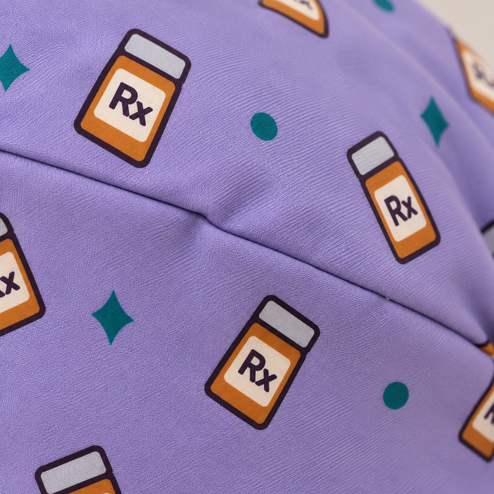 Rx ponytail scrub cap — close-up mockup showing the printed fabric and stitched seam.