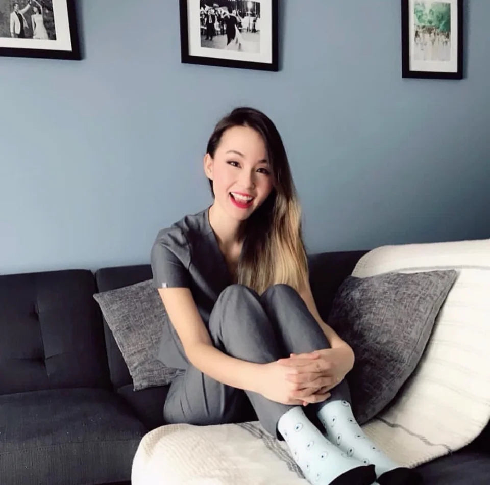 A community member in gray scrubs relaxing on a sofa in pale blue patterned socks.